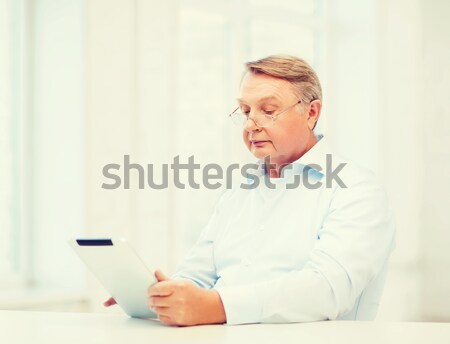 senior woman watching tv and drinking tea at home Stock photo © dolgachov