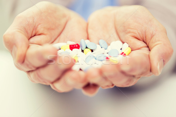 close up of senior woman hands with pills Stock photo © dolgachov