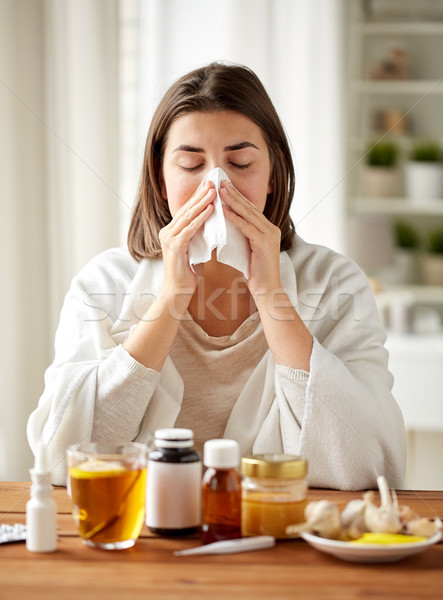 sick woman with medicine blowing nose to wipe Stock photo © dolgachov