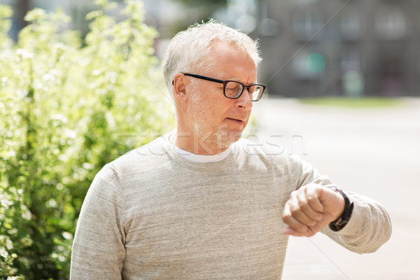 senior man checking time on his wristwatch Stock photo © dolgachov