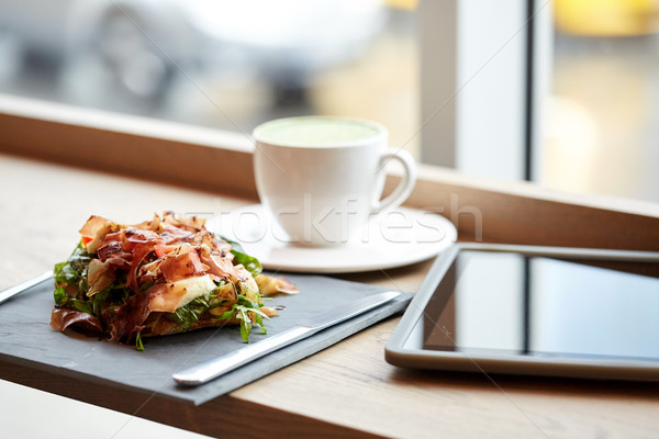 prosciutto ham salad with tablet pc at restaurant Stock photo © dolgachov