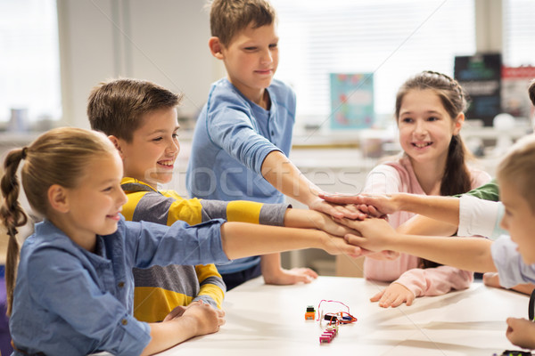 happy children holding hands at robotics school Stock photo © dolgachov