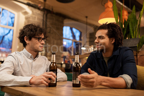 Stock photo: happy male friends drinking beer at bar or pub