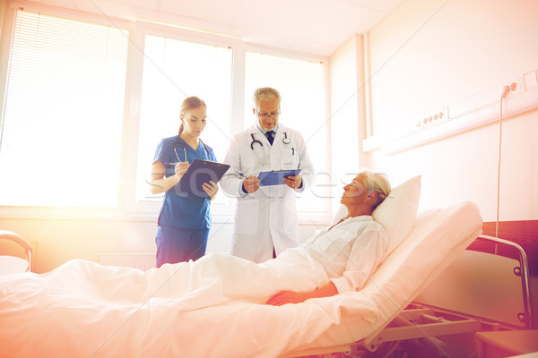 doctor and nurse visiting senior woman at hospital Stock photo © dolgachov