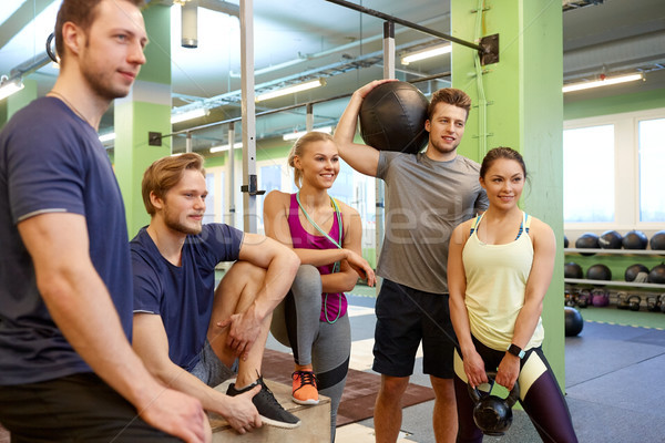 Stock photo: group of friends with sports equipment in gym