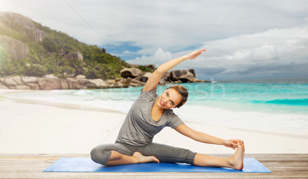 happy woman doing yoga and stretching on beach Stock photo © dolgachov