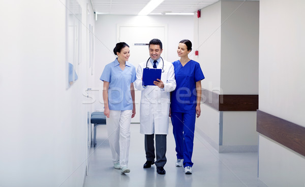 group of smiling medics at hospital with clipboard Stock photo © dolgachov