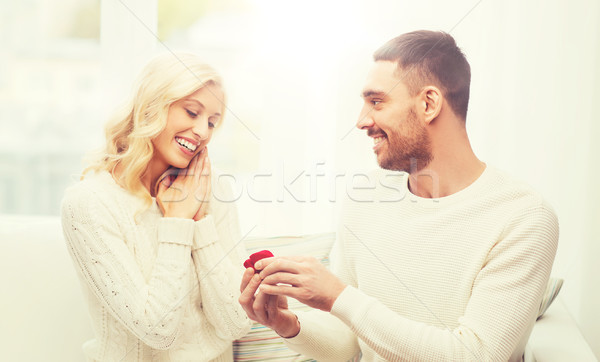 happy man giving engagement ring to woman at home Stock photo © dolgachov