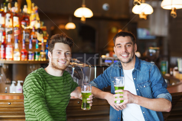 male friends drinking green beer at bar or pub Stock photo © dolgachov