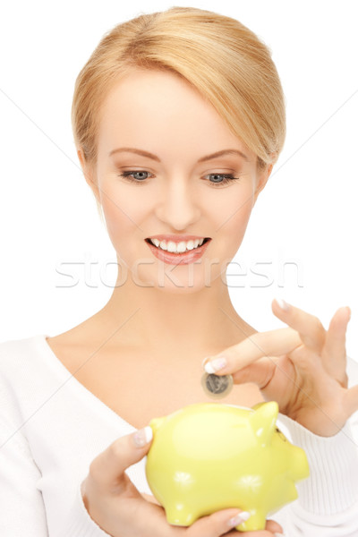 Stock photo: woman with small piggy bank and coin
