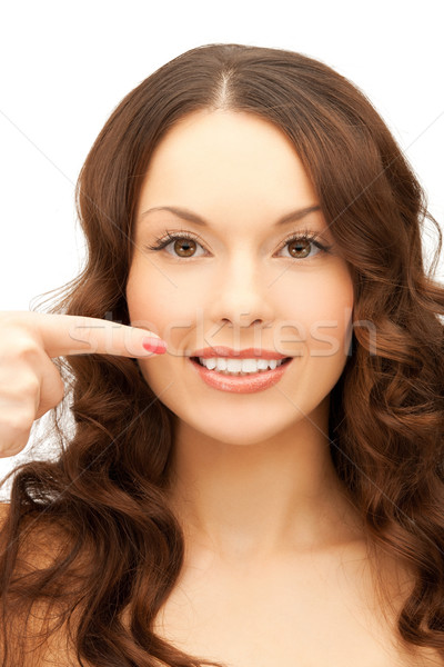 woman pointing at her toothy smile Stock photo © dolgachov