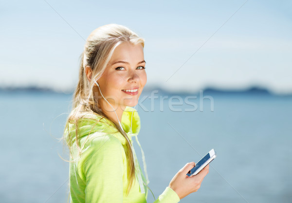 woman listening to music outdoors Stock photo © dolgachov