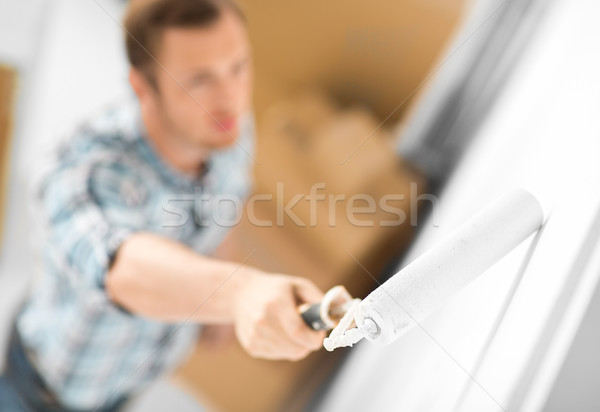 man colouring the wall with roller Stock photo © dolgachov