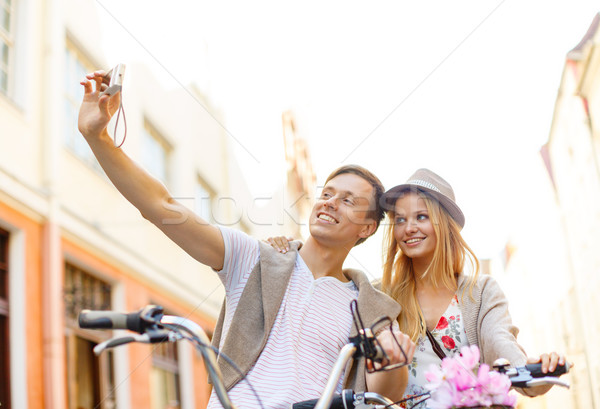 couple with bicycles taking photo with camera Stock photo © dolgachov