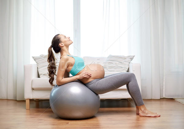 happy pregnant woman exercising on fitball at home Stock photo © dolgachov