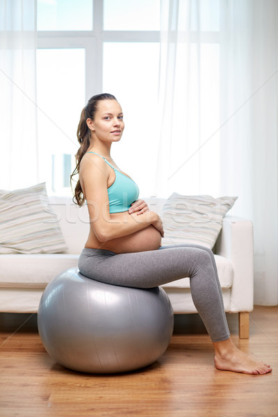 happy pregnant woman exercising on fitball at home Stock photo © dolgachov