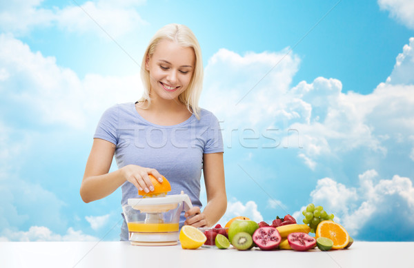 smiling woman squeezing fruit juice over sky Stock photo © dolgachov