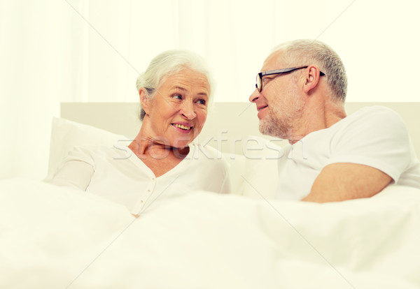 happy senior coupler lying in bad at home Stock photo © dolgachov