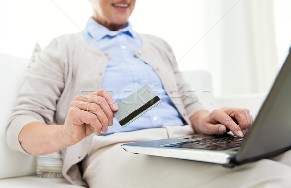 senior woman with laptop and credit card at home Stock photo © dolgachov