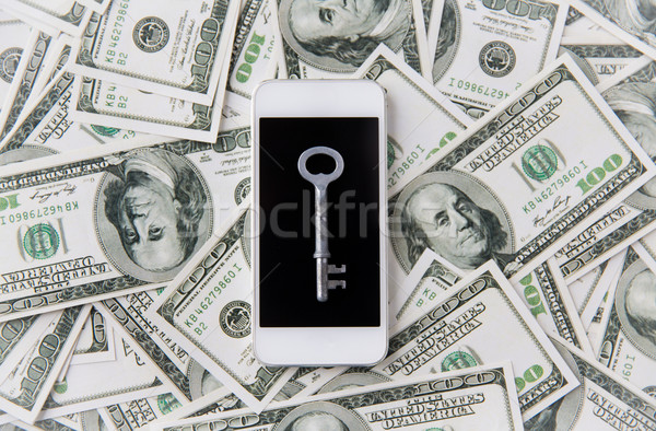 close up of smartphone with key and dollar money Stock photo © dolgachov