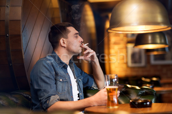 Mann trinken Bier Rauchen Zigarette bar Stock foto © dolgachov