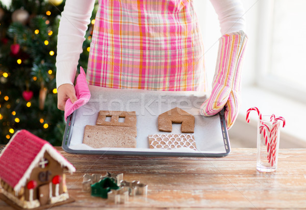 closeup of woman with gingerbread house on pan Stock photo © dolgachov