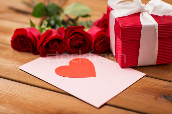 Stock photo: close up of gift box, red roses and greeting card