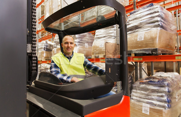 smiling man operating forklift loader at warehouse Stock photo © dolgachov
