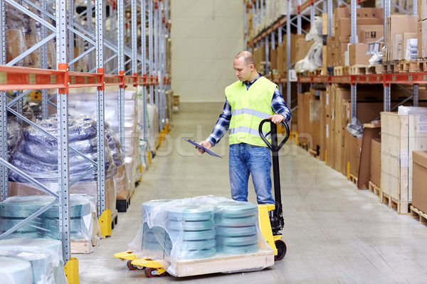 man with loader and clipboard at warehouse Stock photo © dolgachov