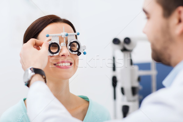 optician with trial frame and patient at clinic Stock photo © dolgachov