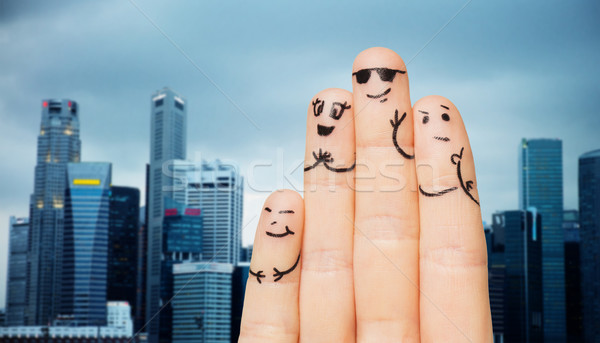 close up of fingers with smiley faces over city Stock photo © dolgachov