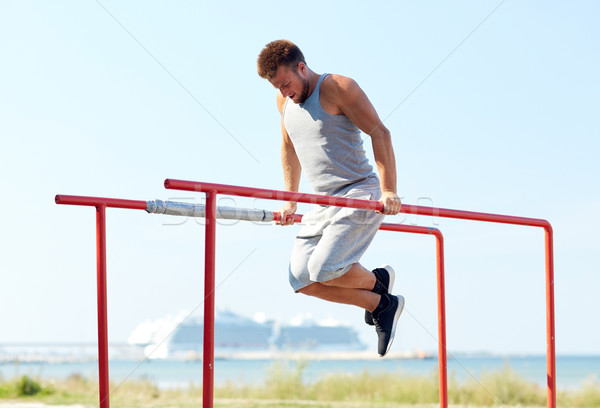 Jeune homme parallèle bars extérieur fitness [[stock_photo]] © dolgachov