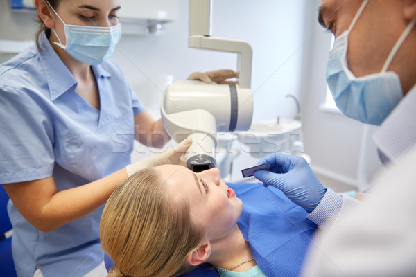 dentists and patient with dental x-ray machine Stock photo © dolgachov