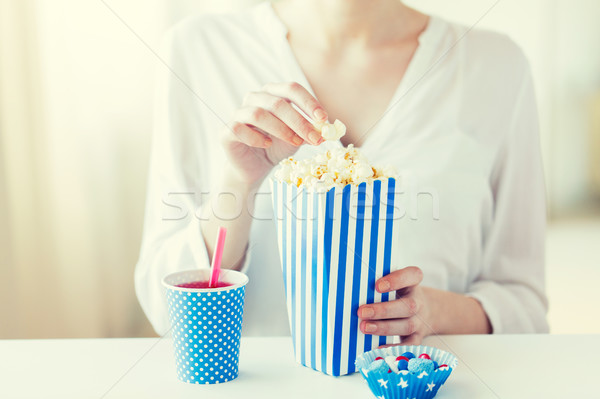 Stock photo: woman eating popcorn with drink and candies