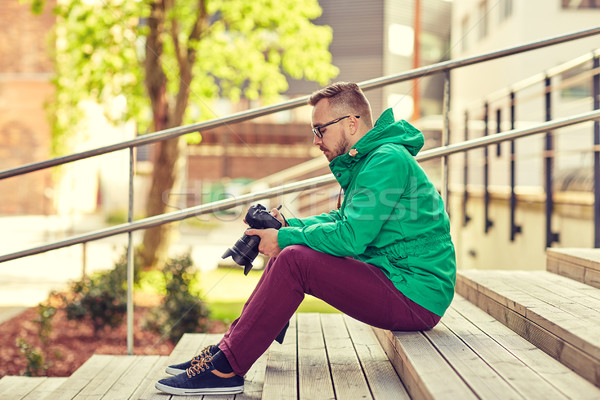 young hipster man with digital camera in city Stock photo © dolgachov