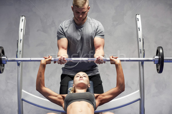 man and woman with barbell flexing muscles in gym Stock photo © dolgachov