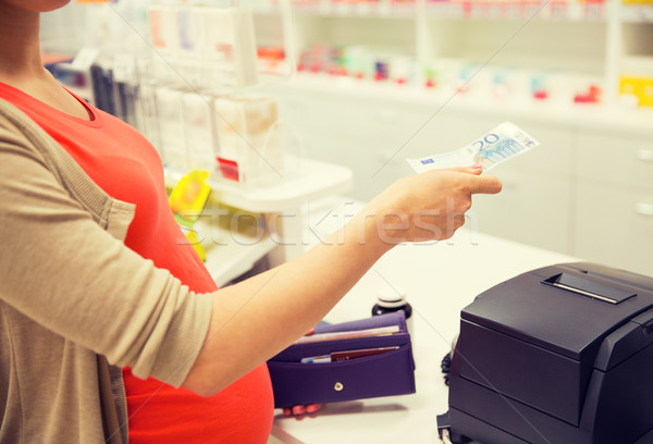 pregnant woman with money at cashbox in drugstore Stock photo © dolgachov