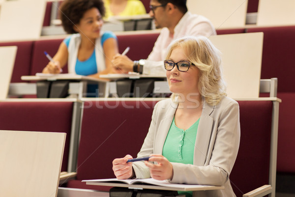 student girl writing to notebook in lecture hall Stock photo © dolgachov