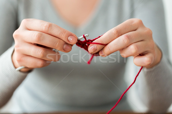 woman knitting with crochet hook and red yarn Stock photo © dolgachov