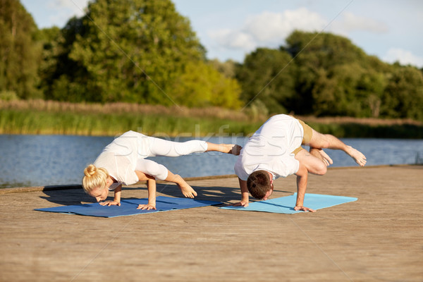 couple making yoga side crane pose outdoors Stock photo © dolgachov