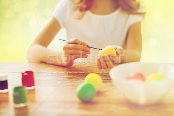 close up of girl with brush coloring easter eggs Stock photo © dolgachov