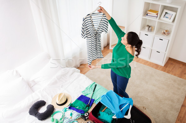 woman packing travel bag at home or hotel room Stock photo © dolgachov