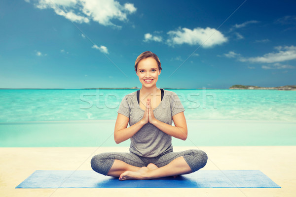 woman making yoga meditation in lotus pose on mat Stock photo © dolgachov