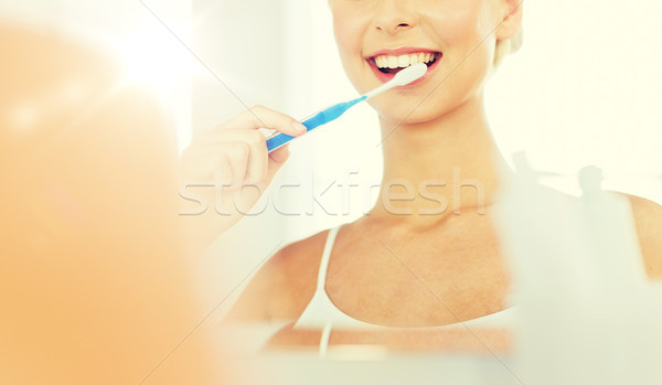 Femme brosse à dents nettoyage dents salle de bain [[stock_photo]] © dolgachov