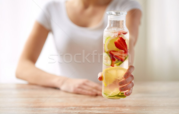 close up of woman with fruit water in glass bottle Stock photo © dolgachov