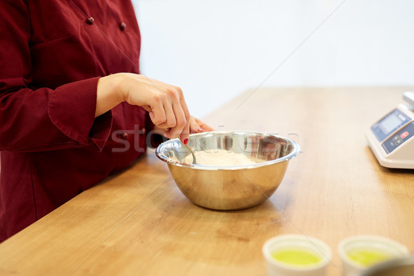 chef with flour in bowl making batter or dough Stock photo © dolgachov