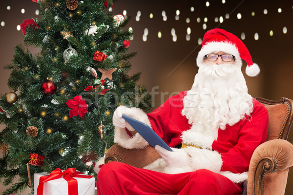 santa claus with tablet pc and christmas tree Stock photo © dolgachov