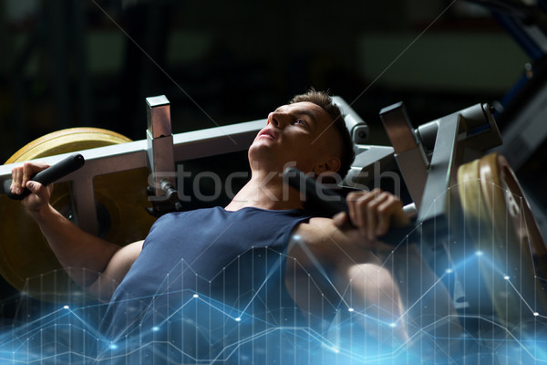man doing chest press on exercise machine in gym Stock photo © dolgachov