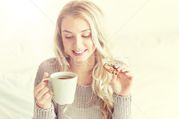 счастливым женщину чай Cookies кровать домой Сток-фото © dolgachov