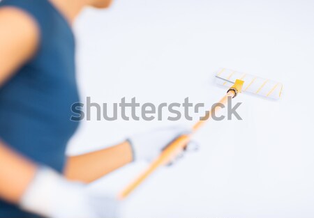 woman with roller and paint colouring the wall Stock photo © dolgachov